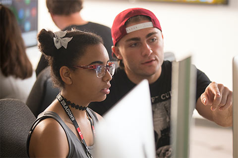 Two students working together in front of a computer