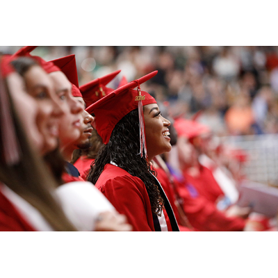 Undergraduates smile in anticipation of accepting their diploma at the podium
