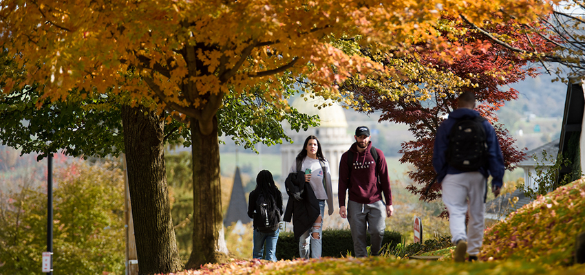 Students walk to campus from downtown during fall.