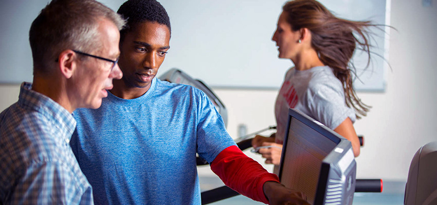 Kinesiology professor and kinesiology major looking at testing data