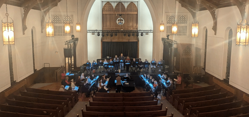 A large choir rehearsing in a church.
