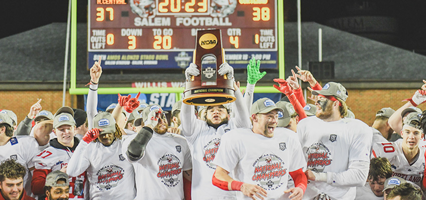 Football team holding the national championship trophy