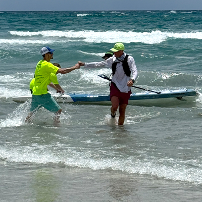 Axtell gives a fist bump with paddleboard in tow