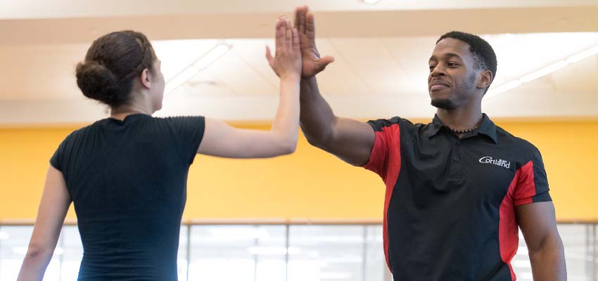 Trainer high-fiving client