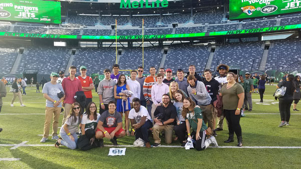 students standing on the field at MetLife Stadium after a trip to a NY Jets game 