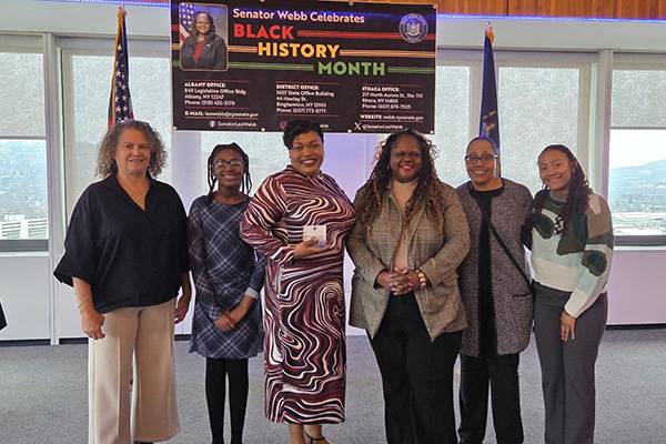 A group of six women pose for a photo as Bernice Cooper, pictured third from left, receives the New York State Senate Commendation Award from Sen. Lea Webb