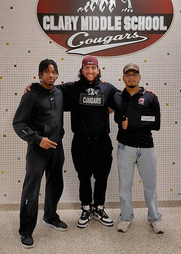 Two C.U.R.E. students, Ikenna Okoye and Joe Martinez, posed for a photo with a C.U.R.E. mentor Andrés Miranda in the middle